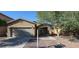 Charming single-story home with a two-car garage, desert landscaping, and a mature shade tree at 7318 W St Charles Ave, Laveen, AZ 85339
