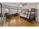 Bedroom featuring a wood-framed bunk bed, a desk, a chair, wood floors, and shuttered windows at 7340 W Bronco Trl, Peoria, AZ 85383