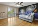 Whimsical bedroom with a unique mural, shutters and ceiling fan at 7340 W Bronco Trl, Peoria, AZ 85383