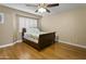 Minimalist bedroom featuring a ceiling fan, hardwood floors and plantation shutters at 7340 W Bronco Trl, Peoria, AZ 85383