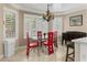 Sunlit dining room features a glass table, red chairs, and plantation shutters at 7340 W Bronco Trl, Peoria, AZ 85383