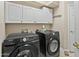 Laundry room with Samsung front-loading washer and dryer, white cabinets, and neutral wall paint at 7340 W Bronco Trl, Peoria, AZ 85383