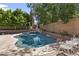 A private backyard pool with mature landscaping, patio, and chairs at 7340 W Bronco Trl, Peoria, AZ 85383