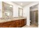 Bathroom featuring dual sinks, granite countertops, and walk-in glass block shower at 7955 E Chaparral Rd # 141, Scottsdale, AZ 85250