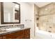 Bathroom featuring granite countertops, tile backsplash, and tiled shower with glass door at 7955 E Chaparral Rd # 141, Scottsdale, AZ 85250