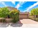 Charming home exterior showcasing desert landscaping, a two-car garage, and a private courtyard entrance at 7955 E Chaparral Rd # 141, Scottsdale, AZ 85250