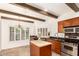 Well-lit kitchen with wood cabinets, stainless steel appliances, an island, tile floors, and ample natural light at 7955 E Chaparral Rd # 141, Scottsdale, AZ 85250