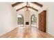 Inviting living room with wood floors, vaulted ceilings, fireplace, arched windows, and exposed beams at 7955 E Chaparral Rd # 141, Scottsdale, AZ 85250