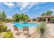 Relaxing pool area with lounge chairs, desert landscaping and waterfall feature under bright blue skies at 7955 E Chaparral Rd # 141, Scottsdale, AZ 85250