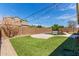 Backyard featuring grass, a pool, brick walls and string lights at 8010 W Atlantis Way, Phoenix, AZ 85043