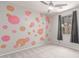 A bright bedroom with gray walls decorated with colorful flower stickers and a ceiling fan at 8010 W Atlantis Way, Phoenix, AZ 85043