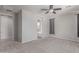 This bedroom has light gray walls, plush carpet, a ceiling fan, and an ensuite bathroom through a doorway at 8010 W Atlantis Way, Phoenix, AZ 85043