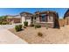 Single-story home with a well-manicured front yard, desert landscaping, and a three-car garage at 8010 W Atlantis Way, Phoenix, AZ 85043