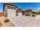 Single-story home with a well-manicured front yard, desert landscaping, and a three-car garage at 8010 W Atlantis Way, Phoenix, AZ 85043