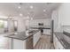Bright kitchen featuring stainless steel appliances, a large island, pendant lighting, and wood-look floors at 8010 W Atlantis Way, Phoenix, AZ 85043