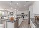 Bright kitchen boasts white cabinets, stainless steel appliances, granite counters and center island with seating at 8010 W Atlantis Way, Phoenix, AZ 85043