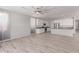 Spacious living room featuring wood-look tile flooring and an open floorplan to the kitchen at 8010 W Atlantis Way, Phoenix, AZ 85043