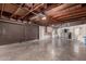 Expansive basement with exposed wooden beams, concrete floors, and laundry area at 8121 N 8Th Ave, Phoenix, AZ 85021