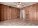 Cozy bedroom featuring wood-paneled walls, a ceiling fan, and built-in storage cabinets at 8121 N 8Th Ave, Phoenix, AZ 85021