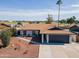 Aerial view of home with desert landscaping, a gray garage door, brown roof, and solar panels at 821 E Harmony Ave, Mesa, AZ 85204