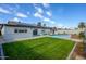 Charming backyard with green grass, a swimming pool, and a patio area, complete with solar panels on the roof at 821 E Harmony Ave, Mesa, AZ 85204