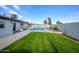 Lush backyard with a well-manicured lawn and a beautiful blue pool, ideal for enjoying sunny days outdoors at 821 E Harmony Ave, Mesa, AZ 85204