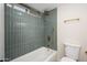 Bathroom displaying a bathtub with shower, blue-green tiling, and sleek gold fixtures at 821 E Harmony Ave, Mesa, AZ 85204