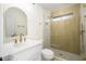 Bathroom showcasing a modern vanity, an arched mirror, gold fixtures, and a glass-enclosed shower at 821 E Harmony Ave, Mesa, AZ 85204