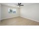 Bright bedroom with modern flooring, ceiling fan, and large window overlooking the backyard at 821 E Harmony Ave, Mesa, AZ 85204