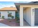 Front exterior of a home featuring a light brick facade, desert landscaping, and a gray garage door at 821 E Harmony Ave, Mesa, AZ 85204