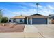 Charming single-story home featuring a gray garage door, a desert-friendly front yard, and white painted brick at 821 E Harmony Ave, Mesa, AZ 85204