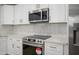 Close up of a modern kitchen showcasing stainless steel appliances, white countertops and cabinets, and tile backsplash at 821 E Harmony Ave, Mesa, AZ 85204