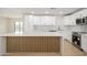 Bright kitchen featuring white cabinets, gold hardware, stainless steel appliances, and a stylish island at 821 E Harmony Ave, Mesa, AZ 85204