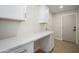 Bright laundry room featuring modern white cabinets with quartz countertops and gold hardware at 821 E Harmony Ave, Mesa, AZ 85204
