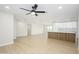 Bright, open living room with modern flooring and ceiling fan flowing into the kitchen at 821 E Harmony Ave, Mesa, AZ 85204