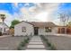Inviting home featuring white painted brick, desert landscaping, and concrete walkway leading to the front door at 9042 N 3Rd Ave, Phoenix, AZ 85021