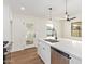 The updated kitchen features white cabinetry, a quartz countertop island, stainless steel appliances, and modern fixtures at 9042 N 3Rd Ave, Phoenix, AZ 85021