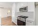 This renovated kitchen showcases stainless steel appliances, white cabinetry and countertop, and modern fixtures at 9042 N 3Rd Ave, Phoenix, AZ 85021