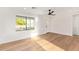 Sun-filled living room features beautiful hardwood floors, a modern black ceiling fan, and a view of the front yard at 9042 N 3Rd Ave, Phoenix, AZ 85021
