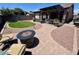 Landscaped backyard with a lush artificial lawn, a fire pit and stone pavers at 913 W Leadwood Ave, Queen Creek, AZ 85140