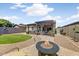 Beautiful backyard with a pergola-covered patio, lush lawn, and inviting fire pit at 913 W Leadwood Ave, Queen Creek, AZ 85140