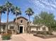 Charming single-Gathering home featuring stone accents, a tile roof, and mature palm trees at 913 W Leadwood Ave, Queen Creek, AZ 85140