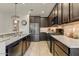 Modern kitchen featuring granite countertops, stainless steel appliances, and dark wood cabinetry at 913 W Leadwood Ave, Queen Creek, AZ 85140