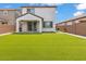 Backyard featuring low-maintenance artificial grass and a covered patio, ideal for relaxation at 9444 W Roma Ave, Phoenix, AZ 85037