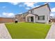 Spacious backyard featuring lush artificial grass, a barbecue grill, and a charming covered patio at 9444 W Roma Ave, Phoenix, AZ 85037