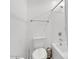 Well-lit bathroom featuring a toilet, bathtub with shower, and modern fixtures in a clean, white setting at 9444 W Roma Ave, Phoenix, AZ 85037