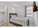Well-lit bedroom with a queen size bed, TV, and neutral color scheme at 9444 W Roma Ave, Phoenix, AZ 85037