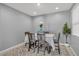 Neutral dining room features a wood table with upholstered chairs and minimalist decor at 9444 W Roma Ave, Phoenix, AZ 85037