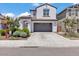 Charming two-story home with a gray garage door, brown tiled roof, and lush landscaping at 9444 W Roma Ave, Phoenix, AZ 85037