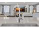 Modern kitchen sink with stainless steel faucet, quartz countertop, and open view to living area at 9444 W Roma Ave, Phoenix, AZ 85037